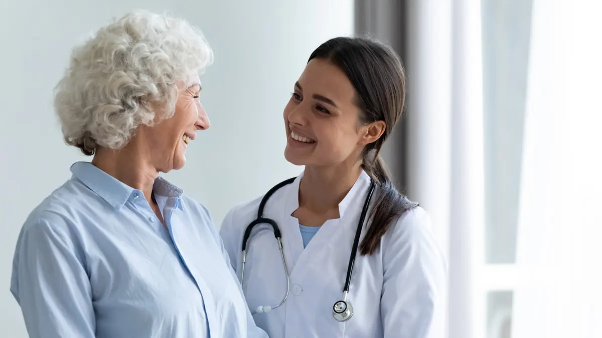 A healthcare professional talks with an older adult.