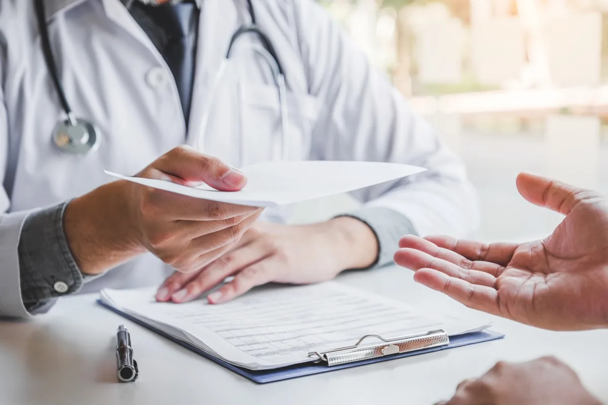 A healthcare professional explains information to someone during a consultation.