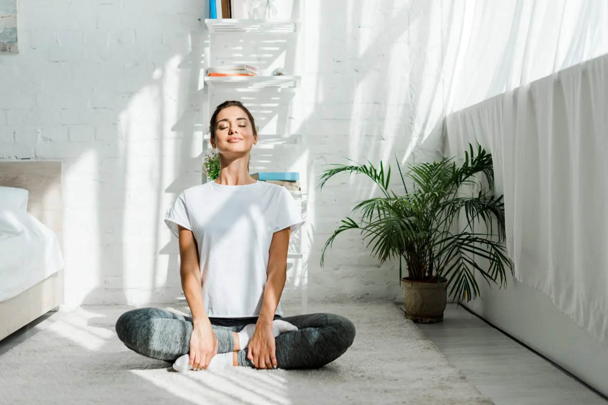A woman sits calmly with her hands resting in her lap.